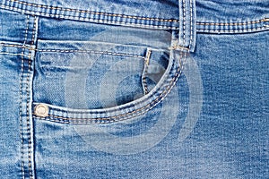 Fragment of the top of the used blue jeans