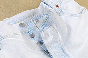 Fragment of the top of the white artificially aged jeans