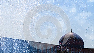 Fragment of traditional Iranian architecture against the blue sky and drops of water. The dome of the traditional national mosque.