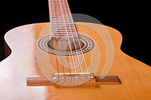 Fragment of traditional wooden acoustic guitar from soundboard side