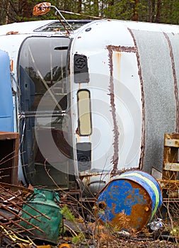 Fragment of trucking dump. Old bus and empty barrels out of fuel