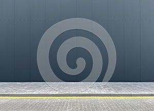 a fragment of an urban concrete wall of a building and an asphalt sidewalk