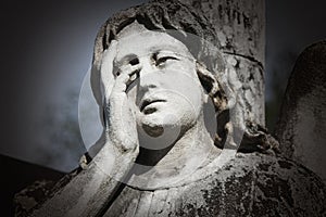 Fragment of vintage statue of a sad ange details photo