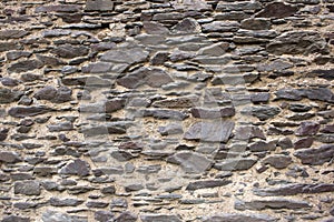 Fragment of the wall from brown flat natural stone
