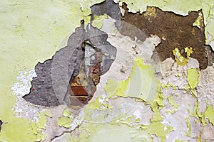 Fragment of a wall with exposed old brickwork under paint and plaster.