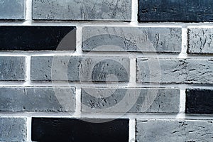 Fragment of a wall made of gray and black bricks. Close-up. Flat lay frame