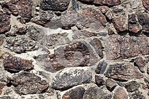 Fragment of the wall of the old house, stone masonry made of natural granite