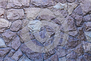 A fragment of a wall of uncrushed rough stone covered with varnish