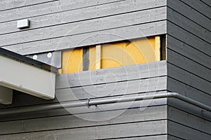 A fragment of a wooden house facade, thermal insulation material, wooden laths and cladding boards