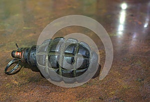 Fragmentation grenade with hole, on camouflage clothing photo