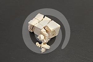 Fragmented cube of yeast isolated on black background