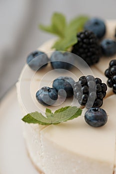 Fragments of classic cheesecake with fresh berries on a gray background.