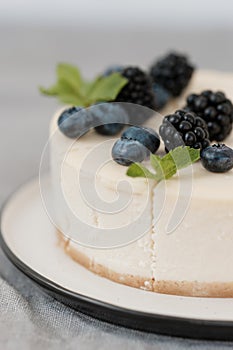 Fragments of classic cheesecake with fresh berries on a gray background.