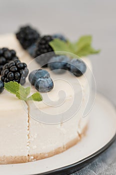 Fragments of classic cheesecake with fresh berries on a gray background.