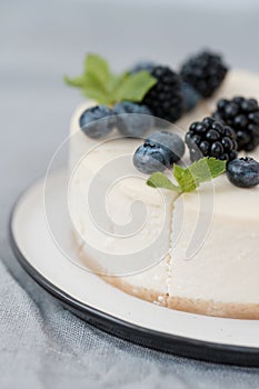 Fragments of classic cheesecake with fresh berries on a gray background.