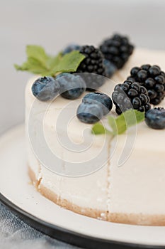 Fragments of classic cheesecake with fresh berries on a gray background.