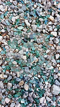 Fragments of colored broken glass with gravel