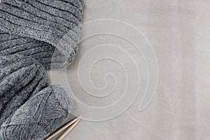 Fragments of knitted clothes on the textured concrete background