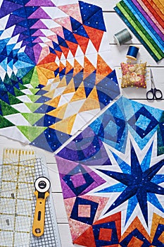 Fragments of quilt, accessories for patchwork, top view on a white wooden surface