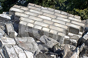 Fragments of a wall of a gray brick at utilization of a brick building