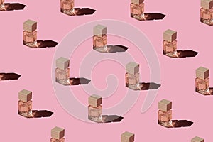 Fragnance parfume pattern. Miniature bottles of pink woman perfume on a pastel pink background, top view. Mockup of fragrance