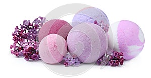 Fragrant bath bombs and lilac flowers on white background