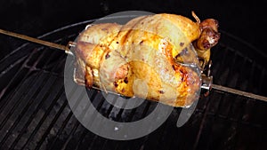 Fragrant chicken is roasted on skewers on the grill rotating