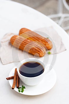 Fragrant coffee with eclairs in the summer cafe