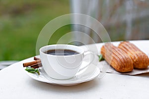Fragrant coffee with eclairs in the summer cafe