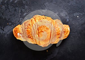 Fragrant croissants on a dark table isolated background. Delicious sweet pastries for breakfast