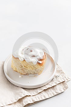 Fragrant freshly baked Cinnamon roll or cinnabon with white cream glaze. Cinnabons recipe. Traditional homemade sweet buns. Pastry