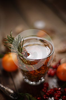 Fragrant fruit tea with tangerines, dried lemons and rosemary on a wooden table. Country style