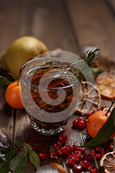 Fragrant fruit tea with tangerines, dried lemons and rosemary on a wooden table. Country style