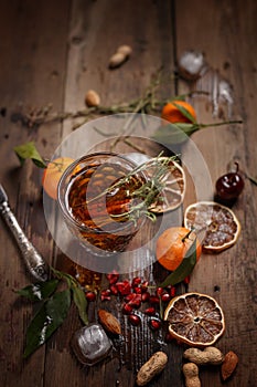 Fragrant fruit tea with tangerines, dried lemons and rosemary on a wooden table. Country style