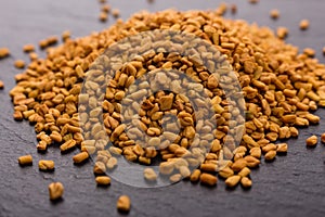 Fragrant grains of fenugreek on a rustic background