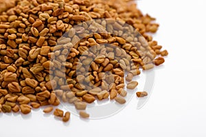 Fragrant grains of fenugreek on a white background