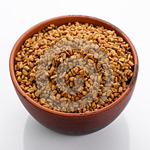 Fragrant grains of fenugreek on a white background