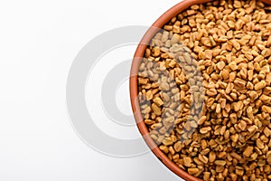 Fragrant grains of fenugreek on a white background