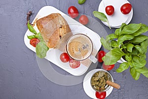 Fragrant morning coffee and a sandwich with mozzarella, pesto sauce with basil for breakfast. Tasty and healthy food. Italian