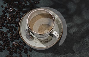 Fragrant strong coffee and coffee beans on a dark green concrete background. The concept of hot drinks.