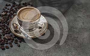 Fragrant strong coffee and coffee beans on a dark green concrete background. The concept of hot drinks.