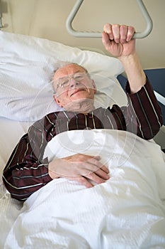 Frail senior man lying in a hospital bed photo