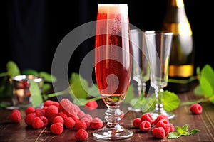 framboise lambic beer in a flute glass, with raspberries around photo