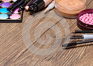 Frame of basic makeup products on wooden surface
