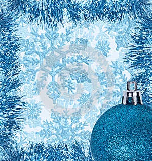 Frame from blue tinsel decorations on snowflack background