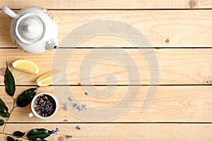 Frame or border of cup of herbal tea, white teapot, lemon and green leaves, view from above, flat lay style composition with free