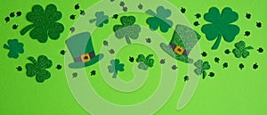 Frame border of shamrock, four leaf clovers and Irish elf hats on green background. Happy St. Patrick`s Day concept