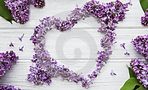Frame of branches and flowers of lilac in the shape of a heart