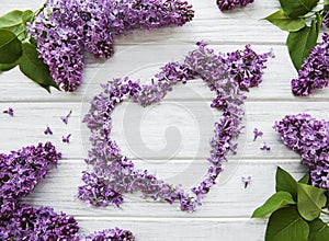 Frame of branches and flowers of lilac in the shape of a heart