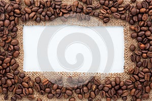 Frame of burlap and coffee beans lying on a white background